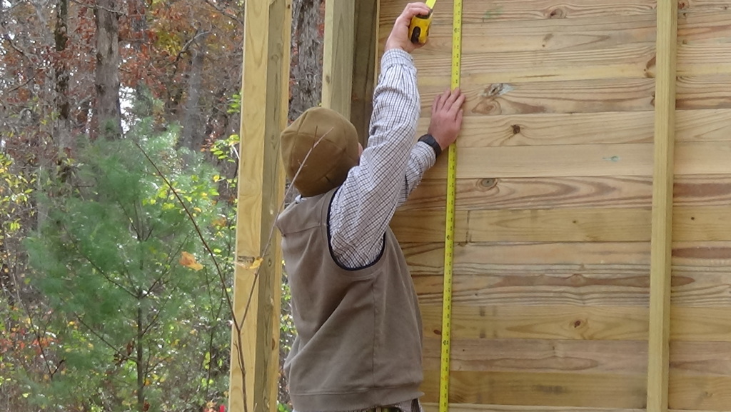 Boy Scout troop leader Chris Garner measures for doors to the aviary enclosures on Nov. 8, at Cumberland Mountain State Park.