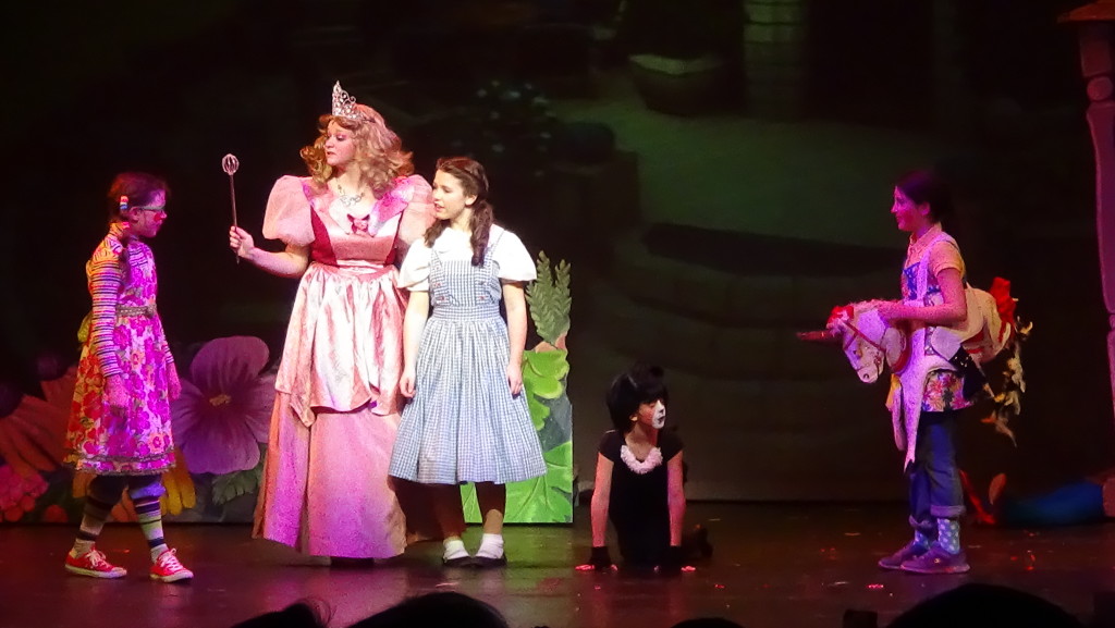 Good witch Glinda (Rachel Masters) and Munchkins greet Dorothy (Emery Smith) and Toto (Taylor Dearman) in Munchkinland. (Photo by Diahan Krahulek / Full Sail University)